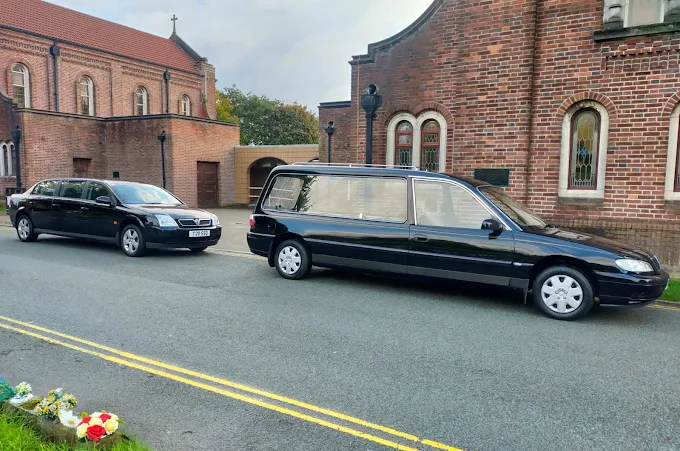 Simple Send-offs hearse and limousine outside a church
